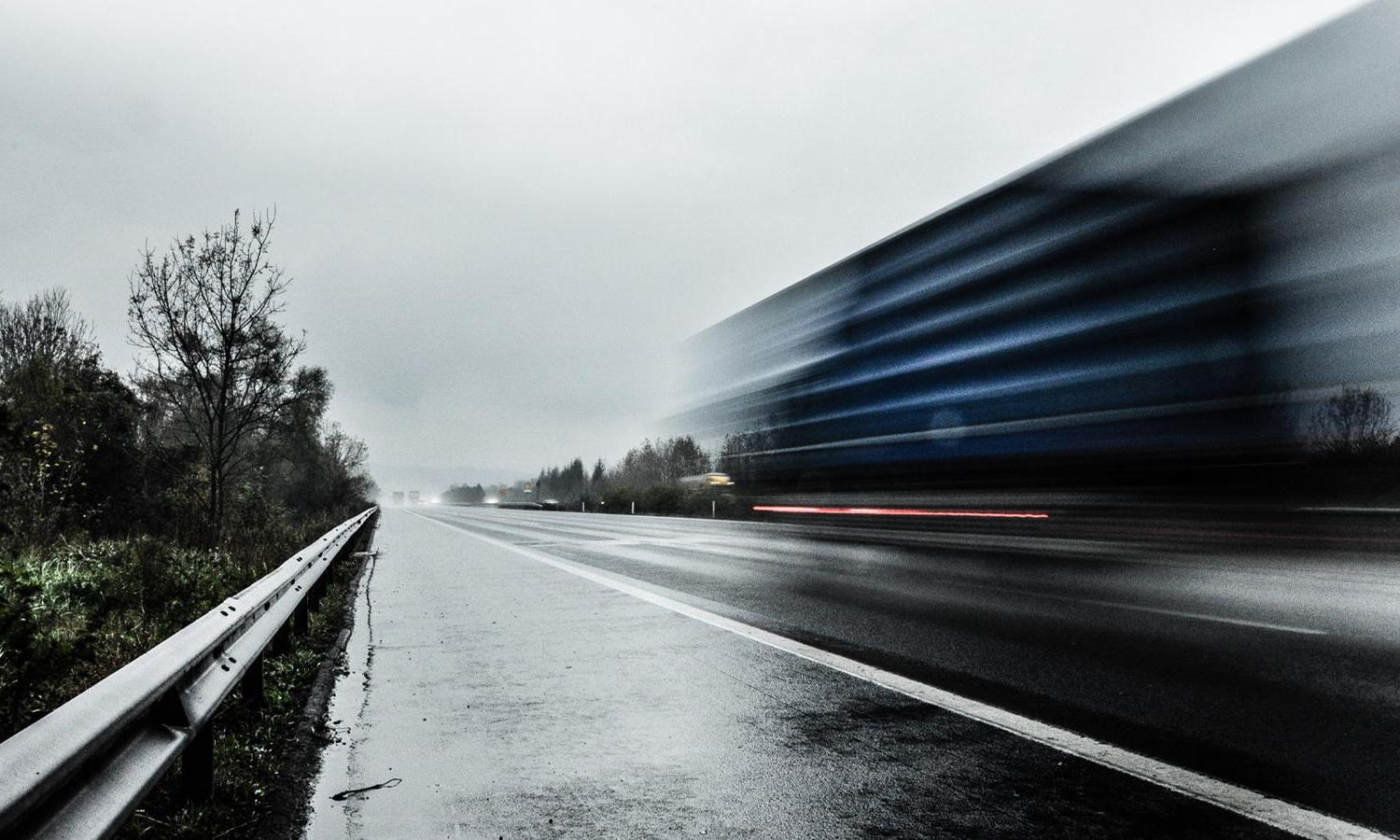 A truck moving fast on a highway.